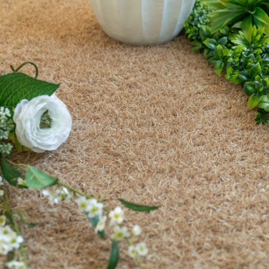 Gazon synthétique de couleur Métropolitain Sable - 22 mm avec fleurs blanches et feuillage vert dans un jardin décoratif