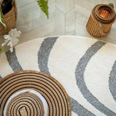 Design fluide du tapis Belle-Île avec ses vagues grises et fond crème