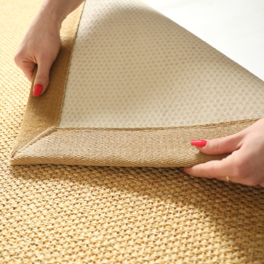 Détail de l’envers du tapis sisal Tulum miel avec la ganse en lin camel 