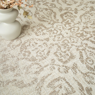 Tapis beige tendre à motif oriental avec accessoires déco dans des tons doux