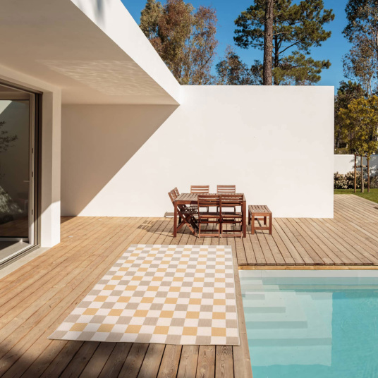 Tapis Andy beige et ocre sur terrasse en bois près de la piscine, style rétro chic