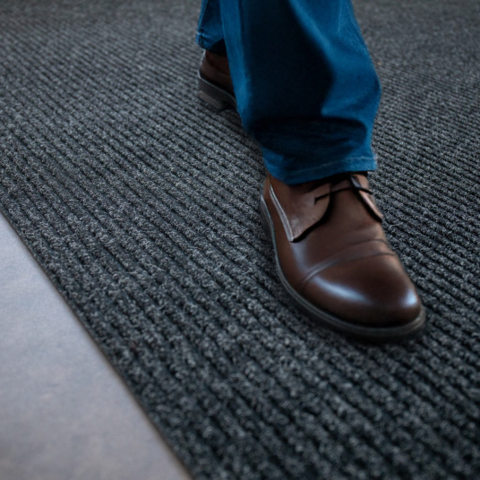 Tapis d’entrée anthracite, contraste raffiné avec chaussures marron