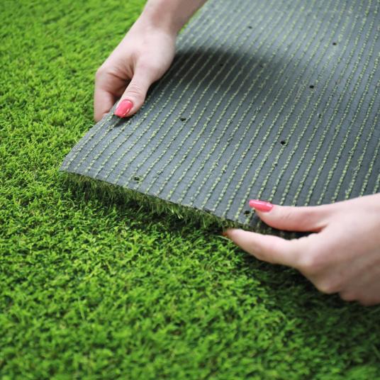 Envers du gazon synthétique Vitalité 30 mm tenu en main, avec une structure résistante