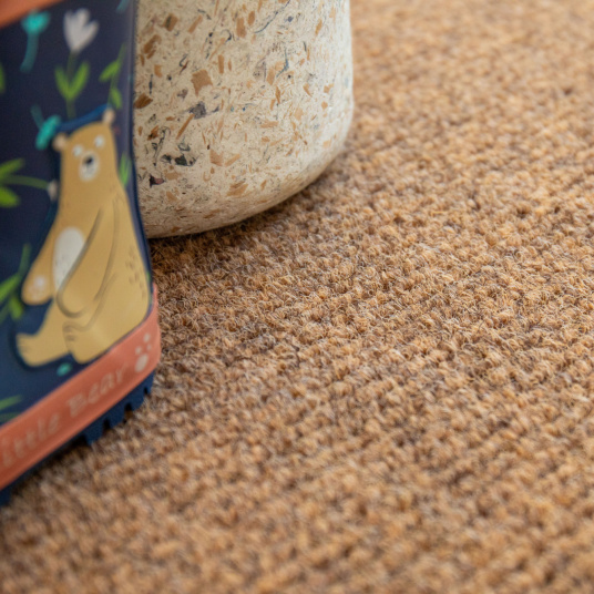 Tapis de propreté sur mesure aspect coco antidérapant avec surface texturée sous une paire de bottes