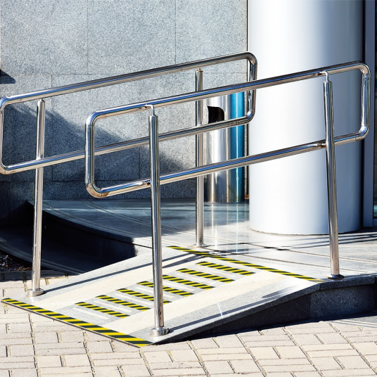 Adhésif antidérapant noir et jaune posé sur rampe d’accès PMR pour sécurisation