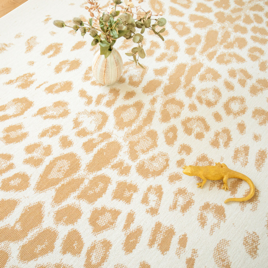 Tapis léopard crème et doré dans un salon lumineux, motif animal chic et graphique