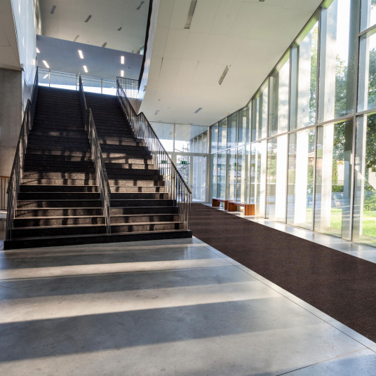 Tapis d'entrée marron au design côtelé dans un bâtiment moderne – antisalissures & antidérapant