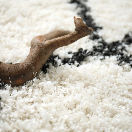 Tapis de salon à poils longs Art Abstrait noir et blanc cassé - gros plan