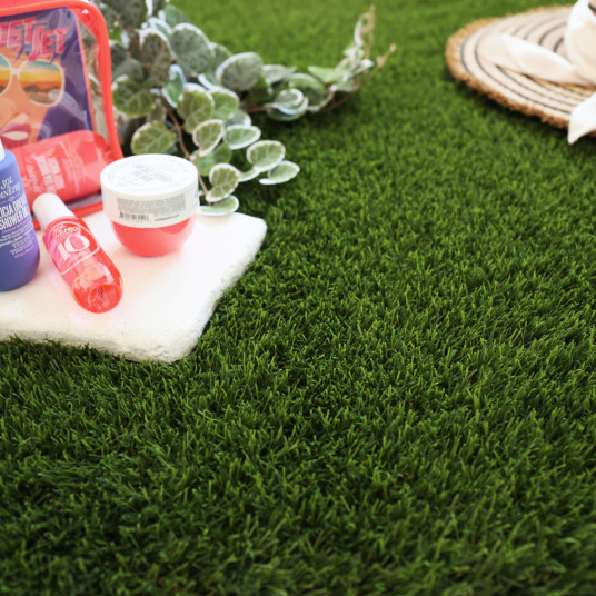 Gazon synthétique Monaco 49 mm en situation déco, plant décoratif et chapeau bohème