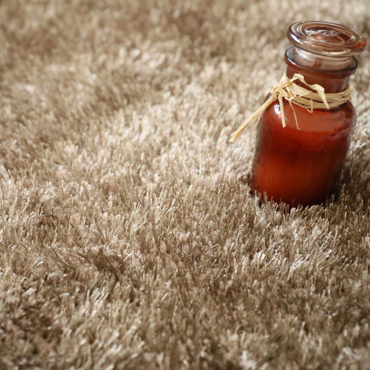 Tapis Éclat shaggy marron clair, texture moelleuse idéale pour marcher pieds nus dans un espace détente