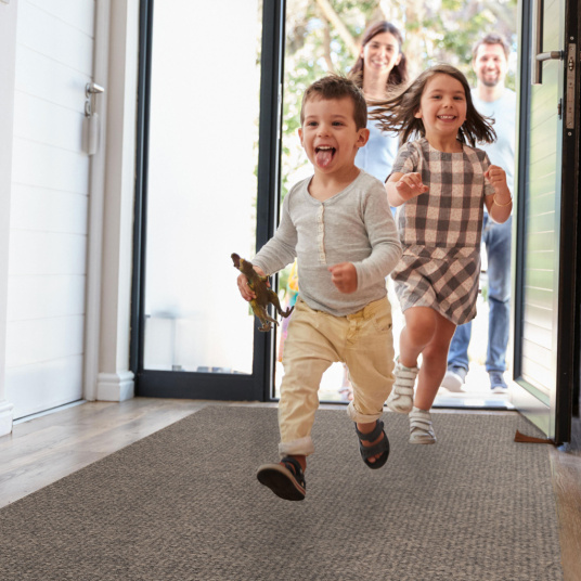 Tapis d'entrée antisalissures beige posé dans un couloir d’entrée, usage résidentiel