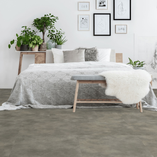 Sol en dalles PVC plombantes effet béton gris clair dans une chambre contemporaine