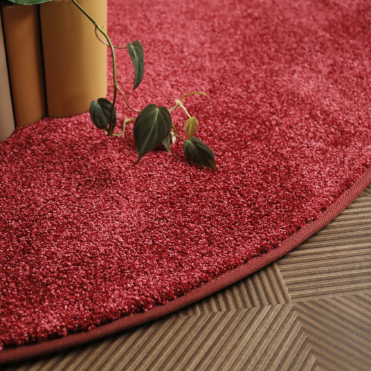 Velours moelleux du tapis rond galonné Feelings Balsan rouge passion à la texture dense et au toucher doux