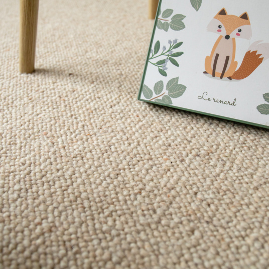 Tapis laine bouclée Latoon grège au sol dans une chambre douce et lumineuse