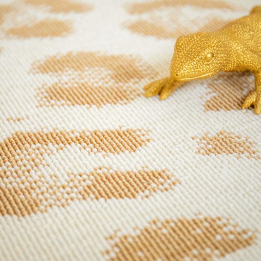 Texture bouclée du tapis léopard crème aux motifs dorés discret et élégant
