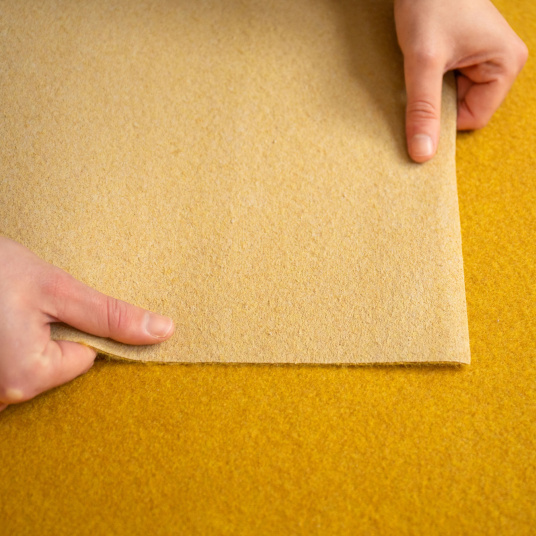 Moquette filmée Stand Event Jaune safran, détail de la sous-face du revêtement pour salons et expositions