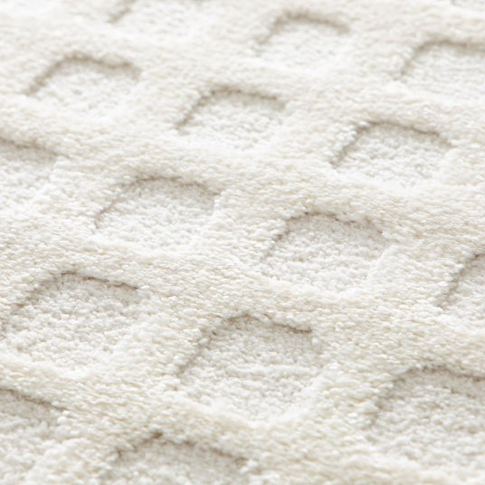 Gros plan sur les poils doux et les formes sculptées en relief du tapis Art Abstrait crème