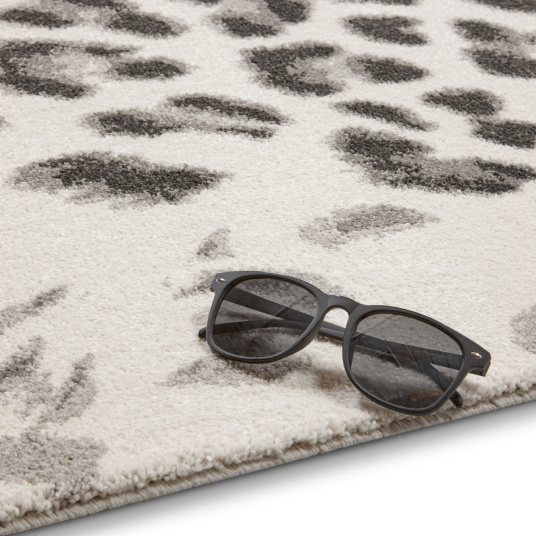 Motif léopard moderne sur fond clair, bordure soignée du tapis Léopard urbain