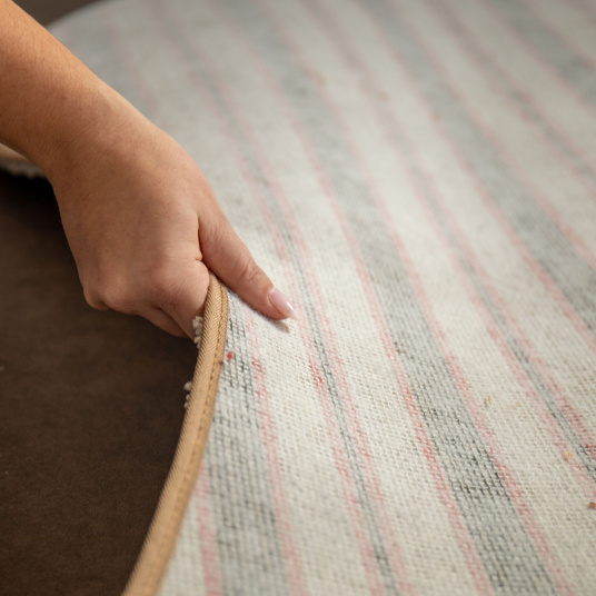 Zoom sur l’envers du tapis organique Select - Ecru, galon beige et texture tissée en gros plan