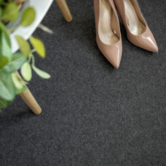 Sol pour stand d’exposition en moquette Stand Event Gris anthracite avec chaussures illustrant l’usage en salon professionnel