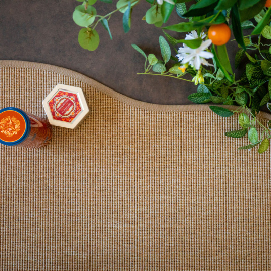 Zoom sur le bord galonné du tapis Mahé, forme organique et finition soignée