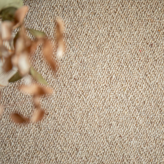 Gros plan sur la texture en laine bouclée du tapis ovale Mallow beige