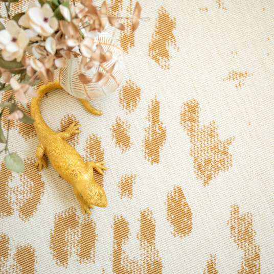 Tapis léopard crème et doré vu du dessus, motif animal raffiné et décoratif