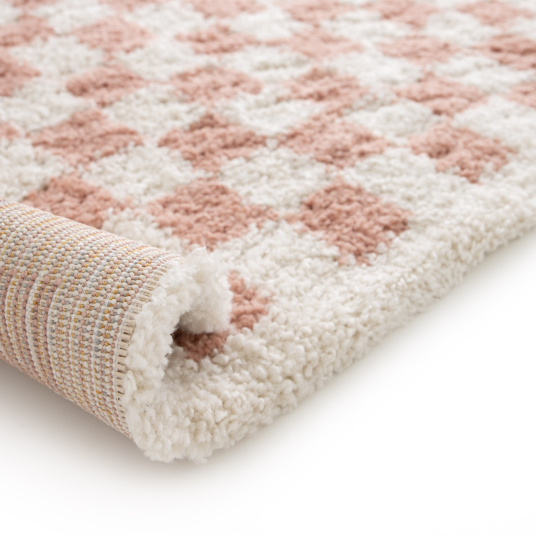Finition et vue sur la trame du tapis damier Colorama rose vintage à poils longs