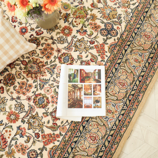 Tapis Mamie in love corail doux en détail avec coussin à carreaux et magazine ouvert