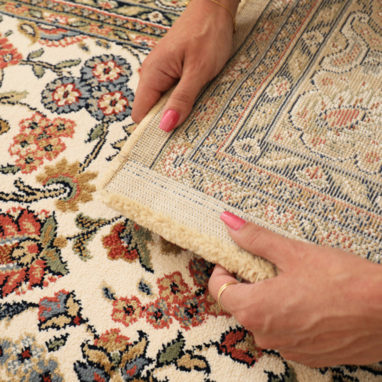 Zoom sur l’envers du tapis Mamie in love corail doux, motif floral et finition tissée