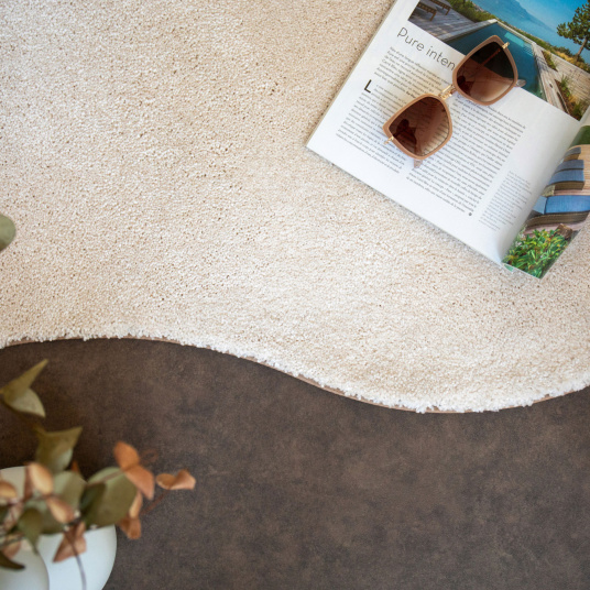 Zoom sur la finition galon beige du tapis contemporain Select écru en forme organique