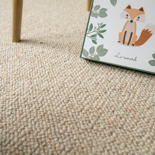 Moquette Latoon grège en pure laine vierge bouclée dans une ambiance douce de chambre avec illustration