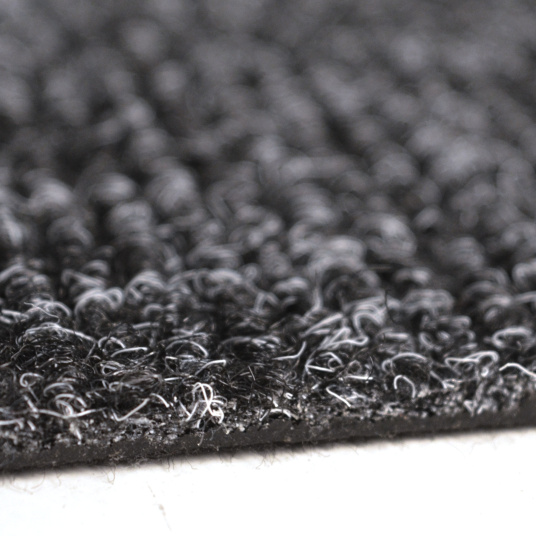 Zoom sur la texture bouclée de la dalle moquette anthracite avec détail matière et fibres résistantes
