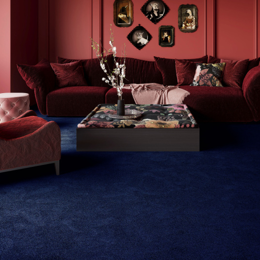 Moquette Pulse Bleu nuit installée dans un intérieur à l’ambiance chaleureuse, idéale pour créer un sol confortable et accueillant