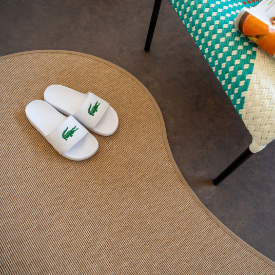 Tapis Mahé Naturel, gros plan sur sa forme organique irrégulière et son style graphique