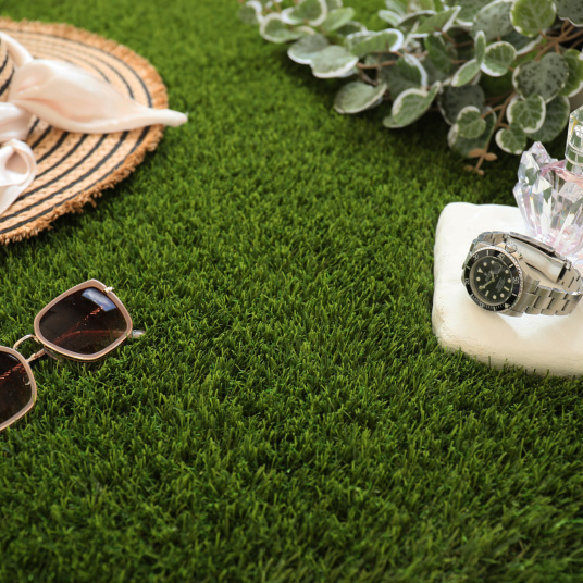 Mise en scène lifestyle sur gazon synthétique Monaco 49 mm avec accessoires d’été