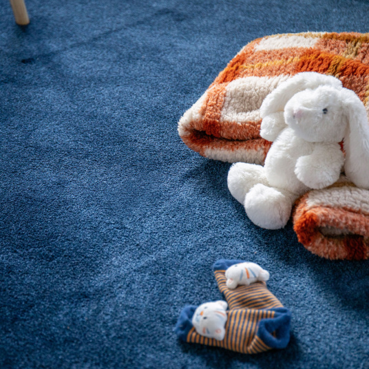 Moquette Pulse bleu nuit dans chambre avec jouets et textile décoratif