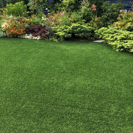 Gazon synthétique Vitalité 30 mm dans un jardin fleuri, rendu réaliste et sans entretien