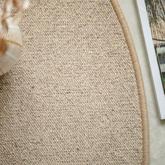 Détail du tapis ovale en laine Mallow beige en forme gélule avec finition surjet