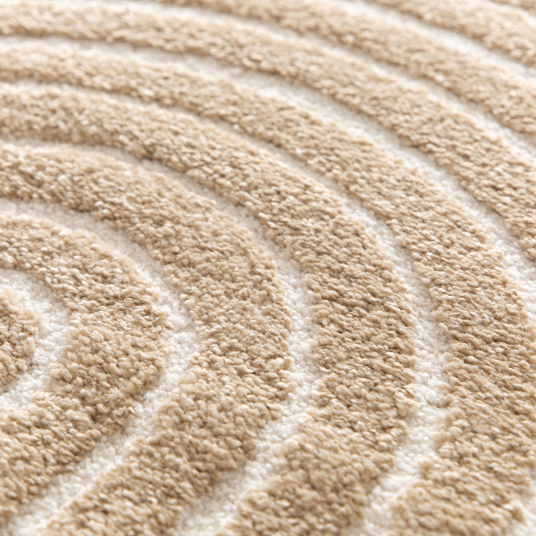 Détail des lignes en relief du tapis Circle, avec ses courbes beige et crème