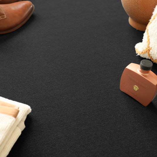 Détail d’une scène décorative avec chaussures et accessoires sur tapis sur mesure Sylon Noir intense