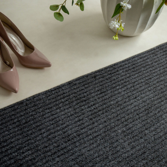 Tapis d’entrée gris, style épuré avec chaussures beiges et éléments déco