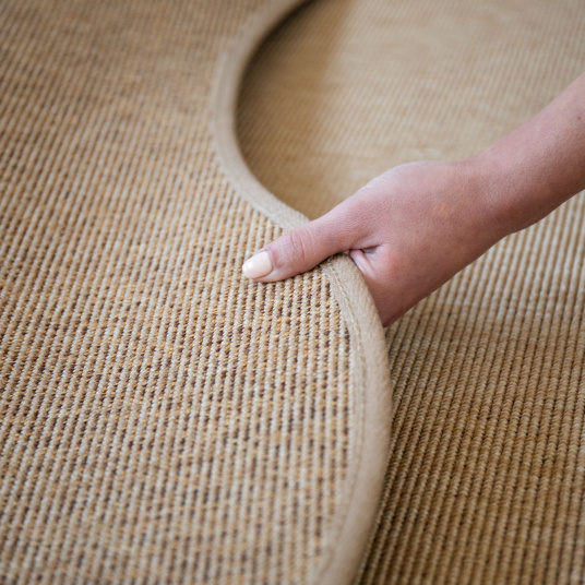 Détail du tapis Mahé Naturel en forme libre, forme organique et finition soignée