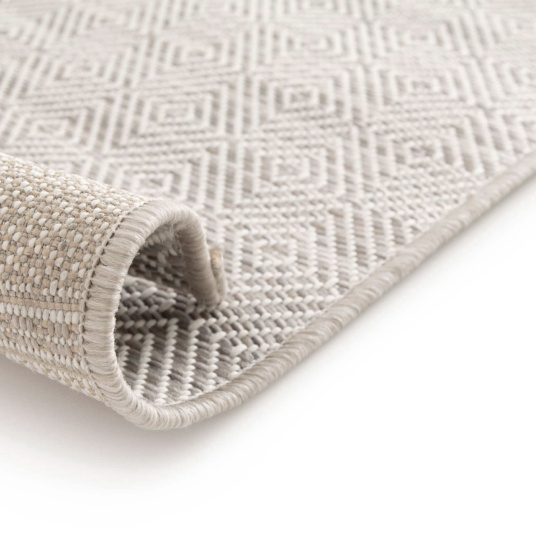 Gros plan sur le bord du tapis Prisma Beige, finitions soignées et résistantes