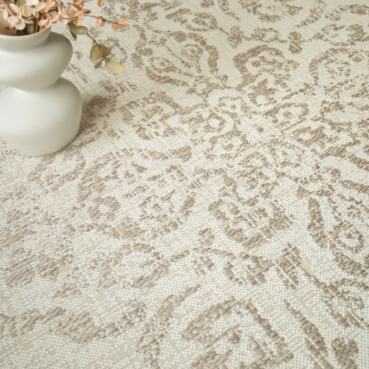 Tapis beige tendre à motif oriental avec accessoires déco dans des tons doux