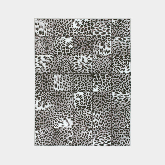 Tapis toucher soft imprimé léopard patchwork noir et blanc vu de dessus, assemblage graphique de carrés à motifs animaliers