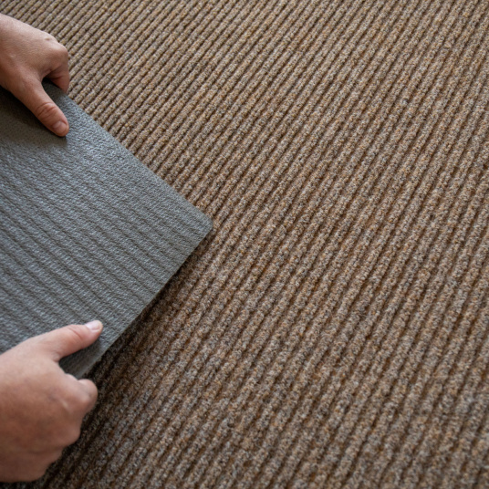 Gros plan sur le tapis d’entrée beige, verso antidérapant en gel caoutchouc