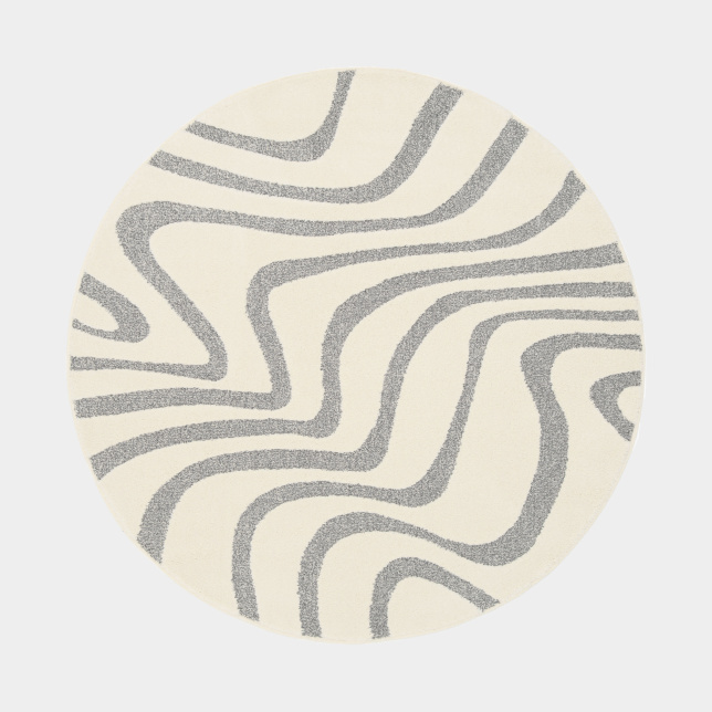 Tapis Belle-Île rond, relief doux et lignes fluides évoquant le sable et la mer