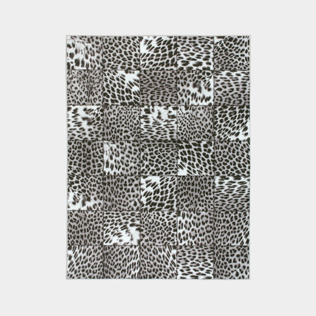 Tapis toucher soft imprimé léopard patchwork noir et blanc vu de dessus, assemblage graphique de carrés à motifs animaliers