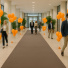 Moquette Revexpo taupe, velours ras pour événementiel, posée dans un hall décoré de ballons orange